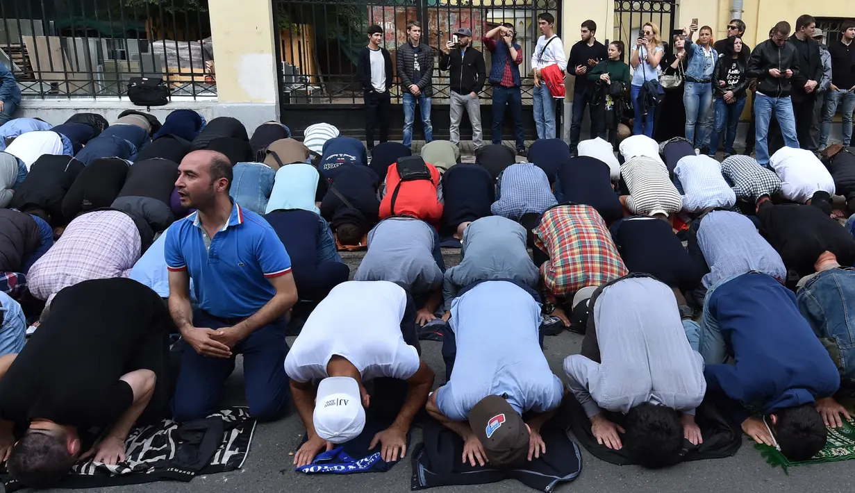 Warga muslim melaksanakan salat saat berunjuk rasa di depan kedutaan besar (Kedubes) Myanmar di pusat kota Moskow, Rusia, Minggu (3/9). Mereka menggelar aksi solidaritas bagi Muslim Rohingya yang tertindas di Rakhine. (Vasily MAXIMOV/AFP)