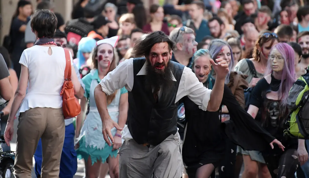 Orang-orang berpakaian menyerupai zombie saat acara Zombie Walk di kota Strasbourg, Prancis, 15 September 2018. Acara Zombie Walk ini dalam rangka Festival Film Fantasi Eropa ke-11 yang berlangsung dari 14 hingga 23 September. (FREDERICK FLORIN/AFP)