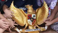 Anak-anak melihat lambang burung Garuda Pancasila di Kampung Pancasila, Karang Tengah, Kota Tangerang, Selasa (1/6/2021). Kegiatan tersebut antara lain seperti gotong royong membersihkan kampung dan sosialisasi penanaman nilai Pancasila kepada warga . (Liputan6.com/Angga Yuniar)