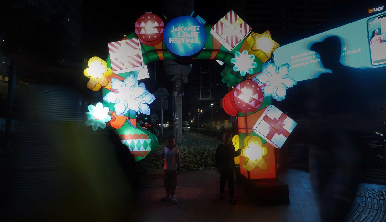 Digelar di sekitar kawasan Bundaran Hotel Indonesia (HI), Jakarta Light Festival digelar untuk memeriahkan momen libur perayaan Natal 2025 dan Tahun Baru 2026. Tampak dalam foto, warga menikmati suasana Jakarta Light Festival 2025 di sekitar Bundara Hotel Indonesia, Jakarta, Selasa (23/12/2025). (Kapanlagi.com/Budy Santoso)