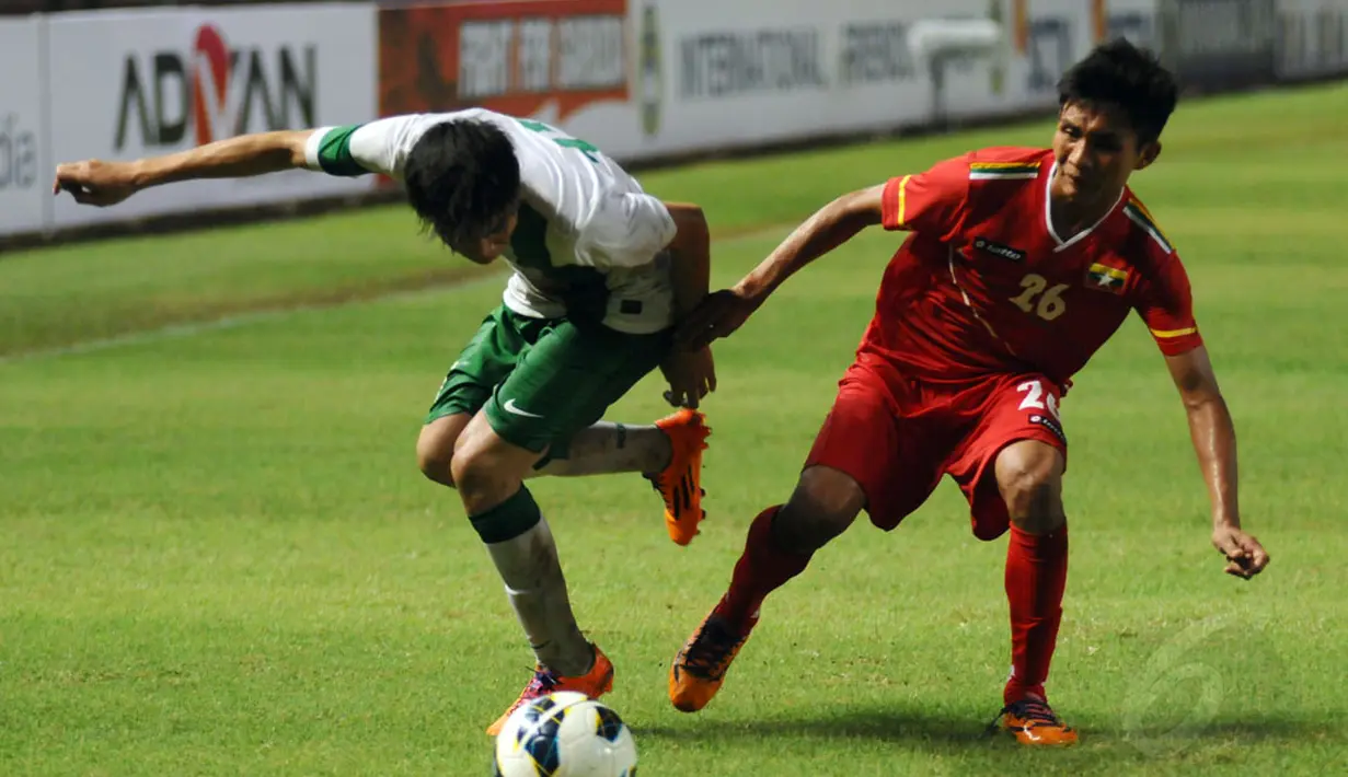 Pemain Timnas Indonesia U-19, Paulo Oktavianus Sitanggang berebut penguasaan bola dengan Chit Hla Aung (Myanmar) di laga persahabatan yang digelar di Stadion GBK Jakarta, (7/5/2014). (Liputan6.com/Helmi Fithriansyah)
