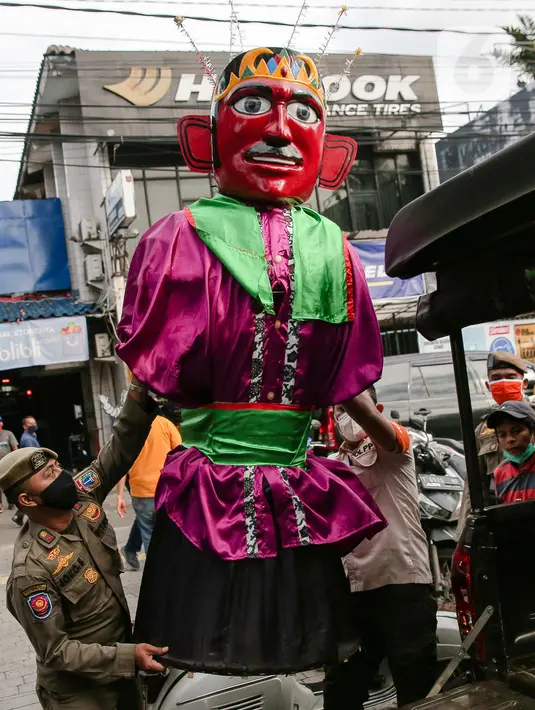 Petugas Suku Dinas Sosial dan Satpol PP Jakarta Selatan merazia pengamen ondel-ondel di kawasan Bulungan, Jakarta, Rabu (24/3/2021). Razia Penyandang Masalah Kesejahteraan Sosial (PMKS) dilakukan untuk ketertiban lingkungan dan terciptanya Ibu Kota yang bebas dari PMKS. (Liputan6.com/Faizal Fanani)