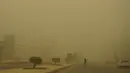 <p>Seorang pria menyeberang jalan selama badai pasir Musim Semi di ibukota Irak, Baghdad (5/5/2022). Irak dihantam oleh serangkaian badai semacam itu pada bulan April, menghentikan penerbangan dan membuat puluhan orang dirawat di rumah sakit karena masalah pernapasan. (AFP/Sabah Arar)</p>