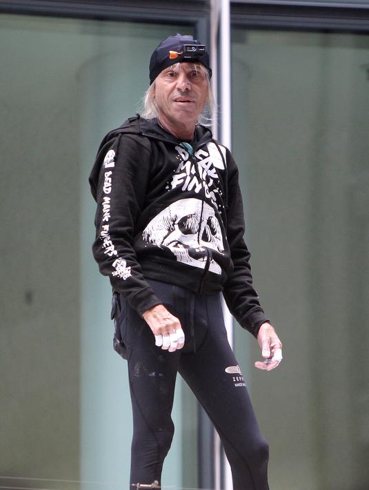 Pendaki kota Prancis, Alain Robert berpose saat memanjat gedung XYZ di Frankfurt am Main, Sabtu (28/9/2019). Pria berusia 56 tahun itu memanjat gedung XYZ tanpa peralatan keselamatan. (AFP Photo/Daniel Roland)