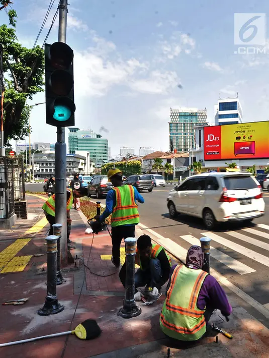 Pekerja memasang Bolar atau tiang pembatas pedestrian di kawasan Tugu Tani, Jakarta, Minggu (9/9). Pemasangan Bolar bertujuan menjaga keindahan jalur pedestrian dan mencegah penyalahgunaan fungsi.(merdeka.com/ Iqbal S. Nugroho)