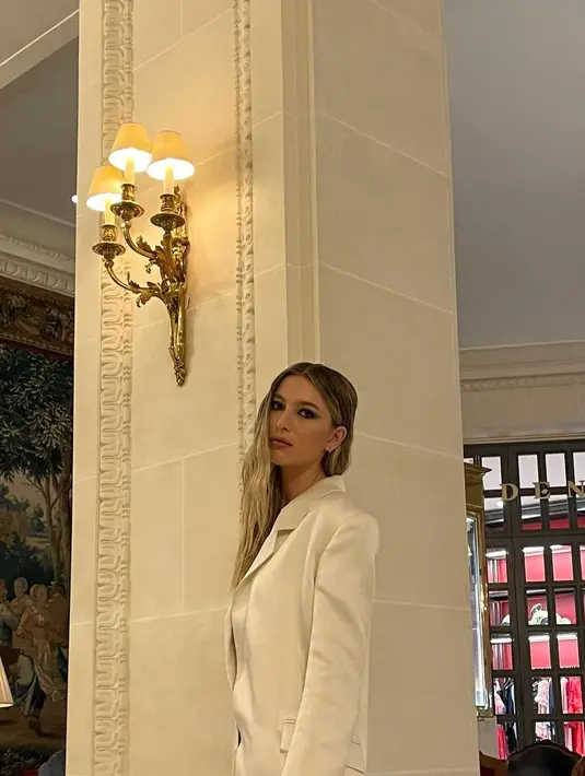 Outfit minimalis menjadi pilihannya di setiap menghadiri acara. Kali ini, ia tampil serba putih dengan kemeja satin dan setelan jas berwarna senada