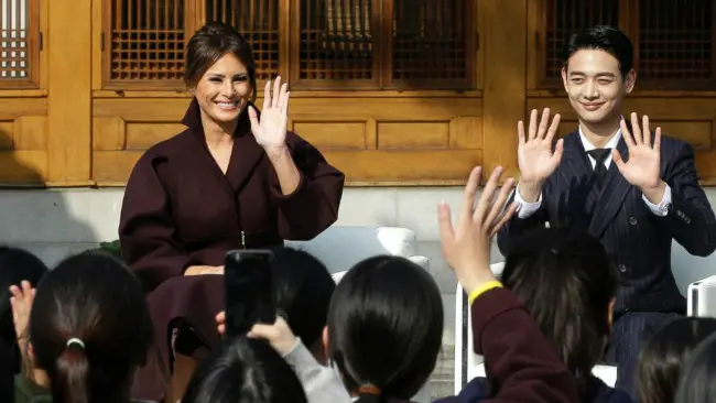 Melania Trump dan Choi Min-ho melambaikan tangan kepada siswi-siswi SMP dalam acara 