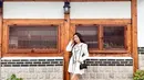 Seperti saat berkunjung ke kampung wisata Hanok ini. Aktris 23 tahun itu tampil manis pakai mini dress putih dengan aksen pita, dipadukan dengan sneakers dan sling bag. (Instagram/natashawilona12).