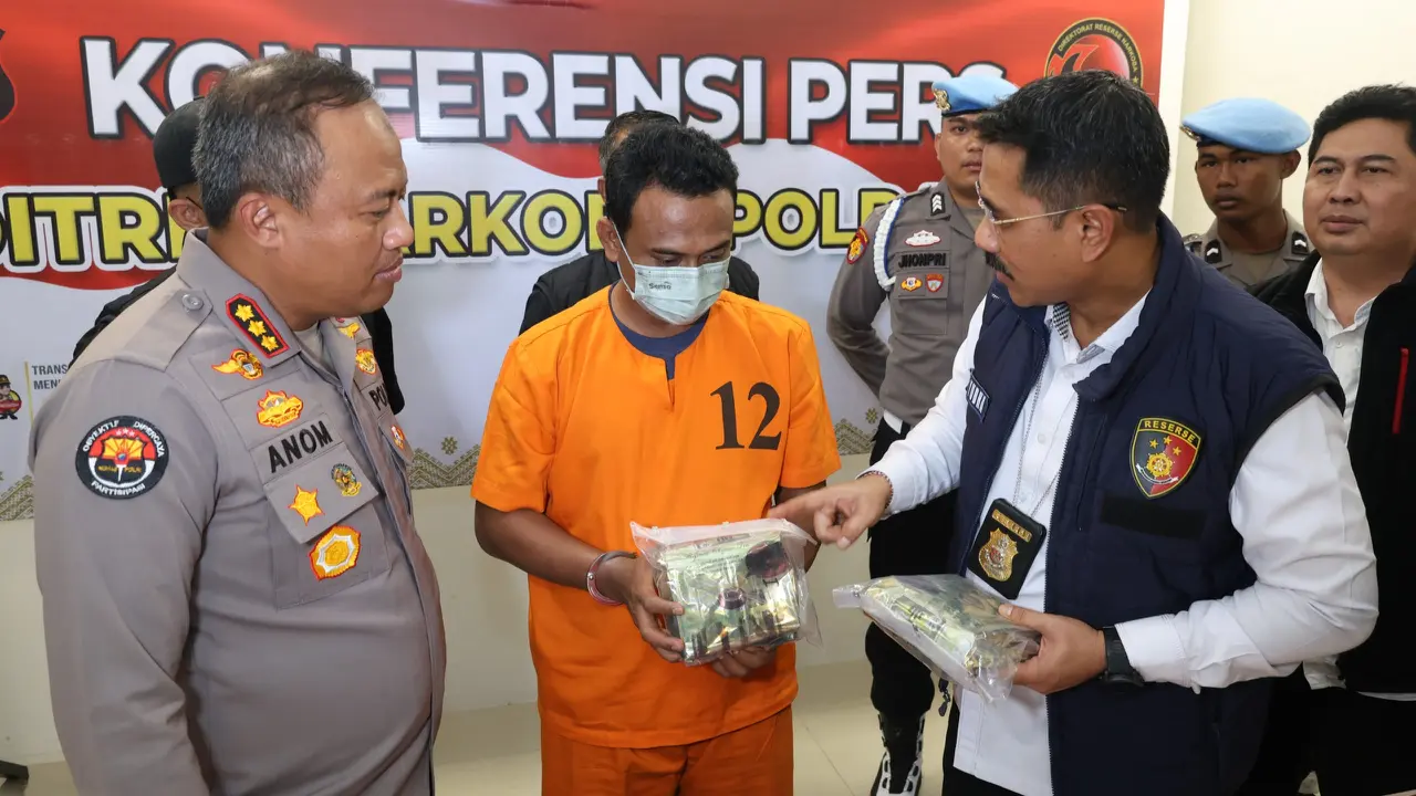 Mantan sekuriti yang menjadi kurir sabu memegang barang bukti di Polda Riau.