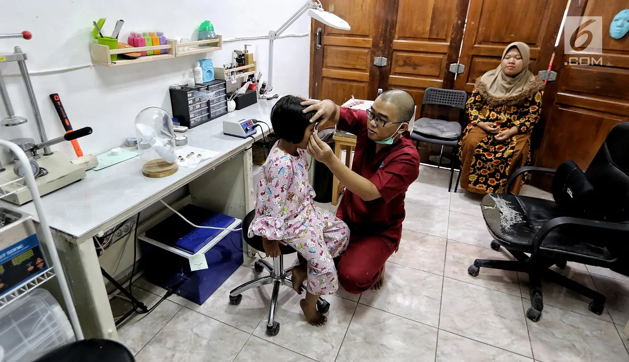 Rizwan Ilyasin sedang memasang bola mata palsu pada mata pasien anak di Klinik Ilyarsi Okularis, Villa Bintaro Indah, Tangsel, Selasa (15/5). Pembagian 23 mata palsu gratis merupakan donasi dari 8 anak perusahaan BUMN. (Liputan6.com/Fery Pradolo)