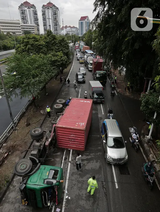 Petugas melakukan evakuasi Kontainer yang terguling di Jalan S Parman, Jakarta Barat, Senin (4/5/2020). Tidak ada korban jiwa dalam kecelakaan tersebut, namun kecelakaan tersebut membuat lalin dijalan itu terimbas kemacetan yang cukup panjang. (Liputan6.com/Johan Tallo)