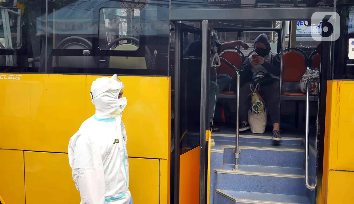 Petugas mengenakan APD saat akan mengantarkan pasien COVID-19 menuju RSDC Wisma Atlet di Puskesmas Kecamatan Tebet, Jakarta, Kamis (3/2/2022). Satgas Penanganan COVID-19 mencatat kenaikan kasus positif COVID-19 dalam satu pekan terakhir. (Liputan6.com/Herman Zakharia)