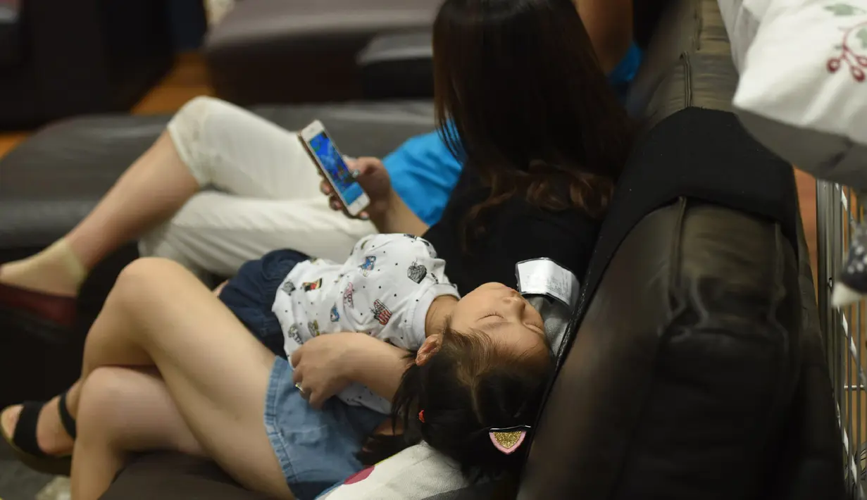 Seorang anak tidur di sebuah pusat perbelanjaan menghindari panas di luar di Hangzhou, di provinsi Zhejiang timur China (24/7). Beberapa pekan terakhir China mengalami suhu udara yang cukup panas. (AFP Photo/Str/China Out)