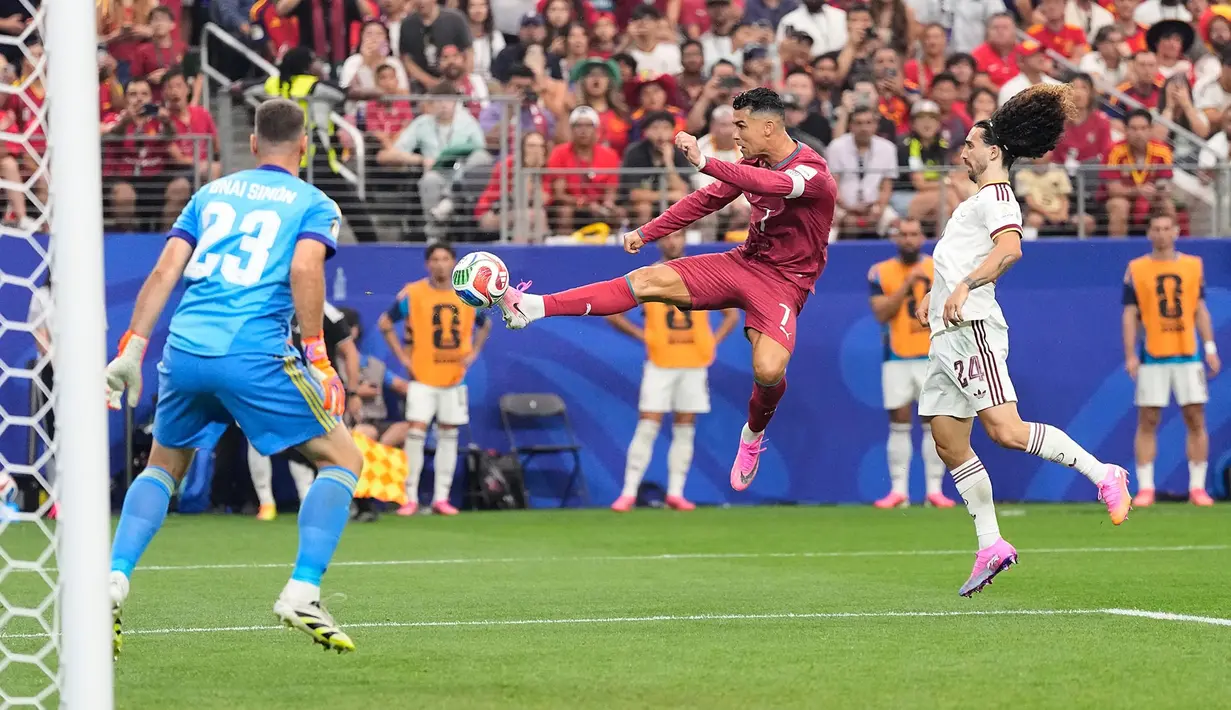 Pemain Portugal Cristiano Ronaldo menembak ke arah kiper Spanyol Unai Simon selama pertandingan sepak bola babak 16 besar Piala Dunia di Arlington, Texas, dekat Dallas, Senin, 6 Juli 2026. (AP Photo/Ashley Landis)