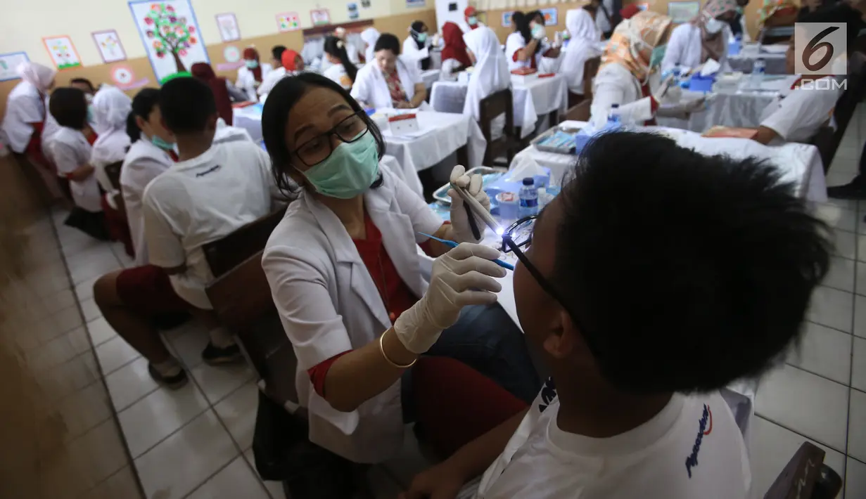 Dokter sedang memeriksa gigi siswa-siswi di di SDN Tebet Timur 01 Pagi, Jakarta, Selasa (20/3). Kegiatan ini digelar memperingati Hari Kesehatan Gigi dan Mulut Sedunia 2018. (Liputan6.com/Pool/Doni)