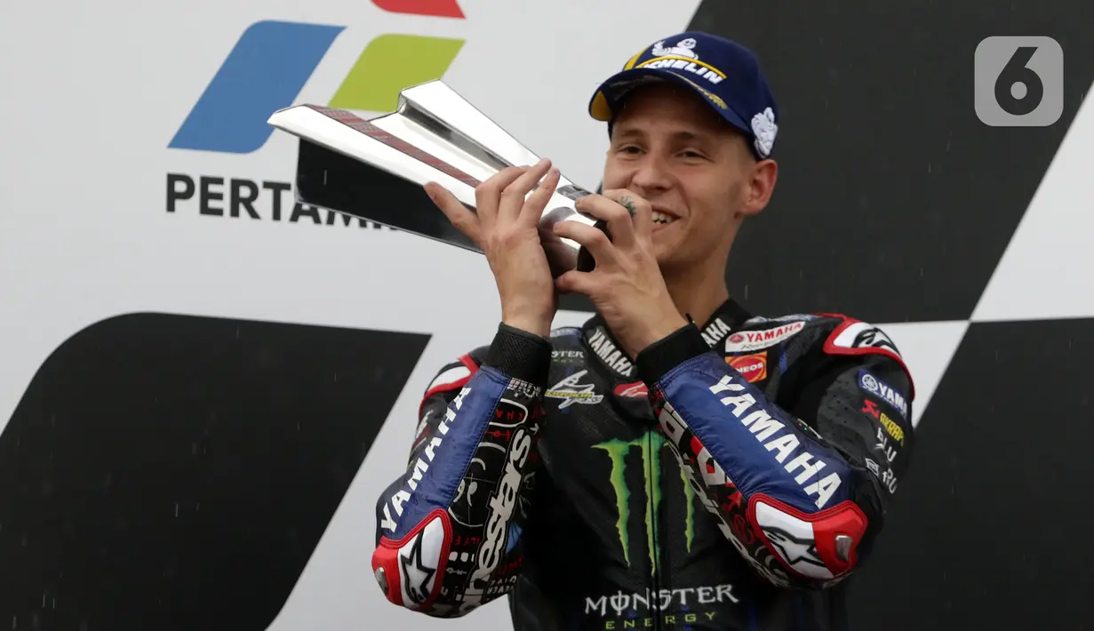 Pembalap Monster Energy Yamaha MotoGP, Fabio Quartararo mencium piala posisi kedua Pertamina Mandalika International Street Sirkuit, NTB, Minggu (20/3/2022). Pembalap Red Bull KTM Factory Racing, Miguel Oliveira menempati posisi pertama MotoGP Mandalika 2022. (Liputan6.com/Helmi Fithriansyah)