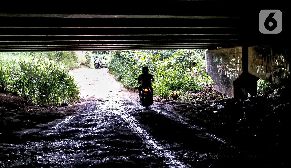 Pengendara sepeda motor melintas di kolong Tol Jagorawi, Cimanggis, Depok, Jawa Barat, Minggu (8/11/2020). Buruknya jalan dan minimnya penerangan membuat akses tersebut rawan aksi kejahatan. (Liputan6.com/Faizal Fanani)