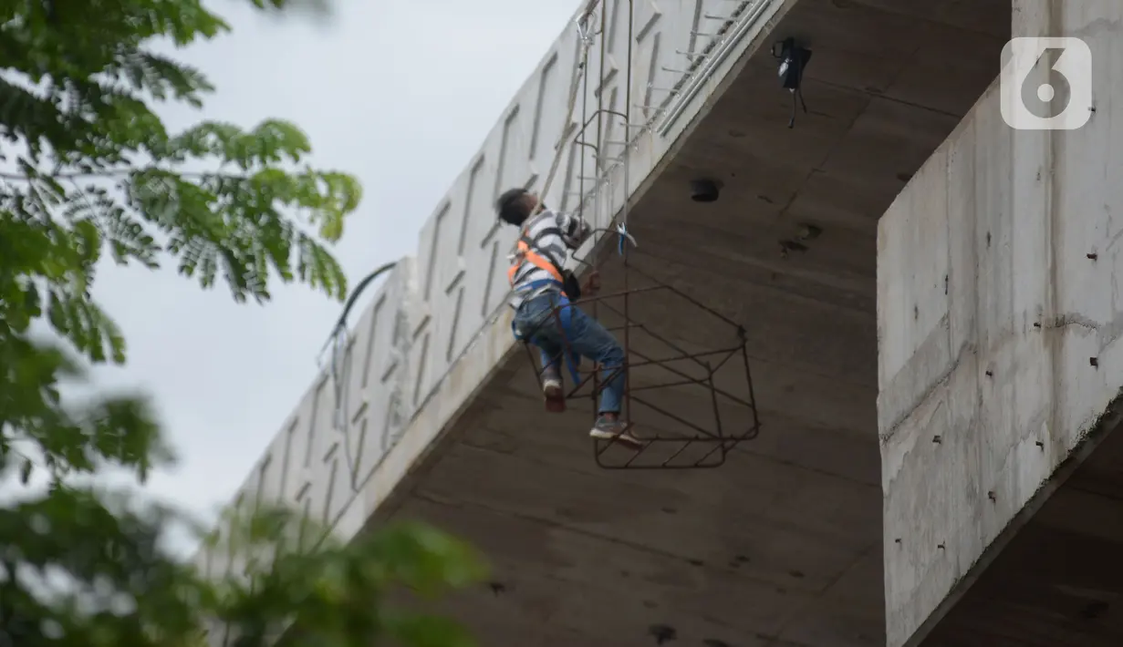 Pekerja beraktivitas di proyek pembangunan jalan layang (flyover) Cakung, Jakarta, Kamis (28/1/2021). Pembangunan jalan  layang dengan panjang 760 meter dan lebar 18 meter ini bertujuan sebagai pengganti pelintasan sebidang kereta api. (merdeka.com/Imam Buhori)