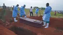 Orang-orang yang mengenakan pakaian pelindung bersiap menurunkan peti jenazah seorang anak berusia enam tahun yang meninggal akibat Ebola, ke dalam liang lahat di Bunia, Provinsi Ituri, Kongo timur, Selasa, 18 Agustus 2026. (Foto AP/Dieudonne Dirole)