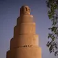 Warga Irak berjalan di menara spiral Malwiya, monumen nasional Irak yang berharga pada pertengahan abad kesembilan, di dalam Kota Arkeologi Samarra, di Samarra, utara Baghdad (26/7/2022). Menara helikoid 50m dari batu bata yang dikeringkan dan dipanggang dengan sinar matahari, mencontoh ziggurat kuno yang dibangun untuk melambangkan kekuatan Islam selama kekhalifahan Abbasiyah, terdaftar sebagai Situs Warisan Dunia UNESCO pada tahun 2007. (AFP/Ismael Adnan)