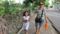 Angeline bersama dengan ibu angkatnya Margriet sedang berjalan kaki di Bali. Angeline terlihat sedang membawa anak kucing. Foto ini diberi keterangan bahwa Angeline menemukan anak kucing yang terlantar. (Facebook.com/Find Angeline - Bali's Missing Child)