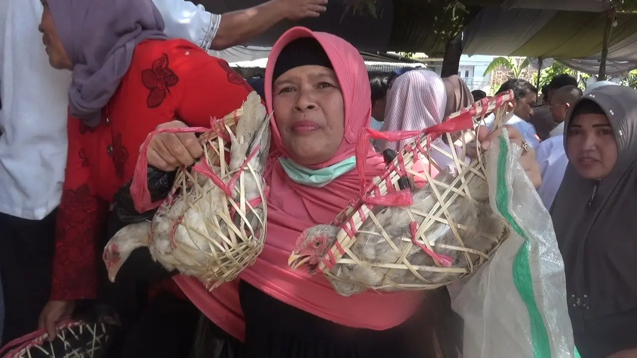 Salah seorang jemaah majelis tarbiyah, Wanaraja, Garut, Jawa Barat nampak tengah menerima pemberian 2 ekor ayam dalam perayaan 1 Muharram 1441 Hijriah di Garut