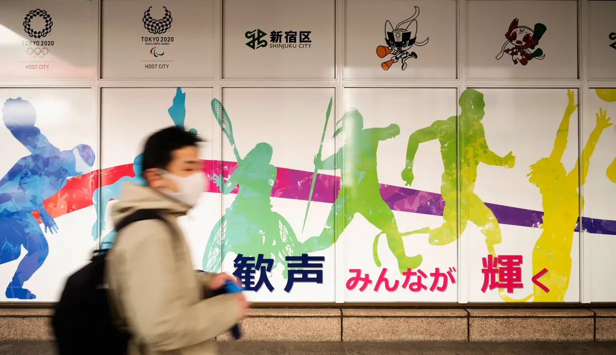 Seorang pria bermasker mengunjungi Balai Kota Shinjuku yang mempromosikan Olimpiade Tokyo 2020 yang dijadwalkan ulang untuk musim panas ini, di Tokyo, Jumat (29/1/2021). Olimpiade Tokyo digelar sesuai jadwal pada 23 Juli-8 Agustus 2021 setelah ditunda setahun karena Covid-19. (AP Photo/Hiro Komae)