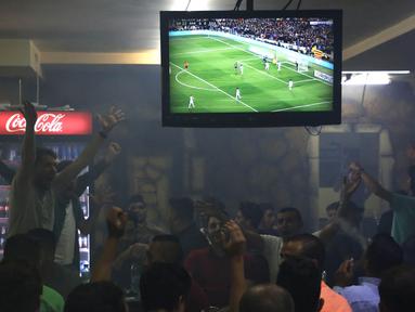 Warga Palestina menonton laga El Clasico antara Barcelona melawan Real Madrid di West Bank City, Ramallah, Minggu (6/5/2018). Konflik perang tak menyurutkan fenomena El Clasico. (AFP/Abbas Momani)