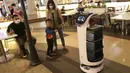 Robot bernama “Bellabot” melintasi pengunjung food court di Tangcity Mal, Kota Tangerang, Rabu (27/10/2021). Robot itu bertugas sebagai pramusaji guna meminimalisir sentuhan langsung antara pegawai dan pengunjung di saat aktivitas mal mulai beroperasi dalam masa pandemi. (Liputan6.com/Angga Yuniar)