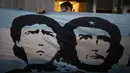 Penggemar berdiri di belakang spanduk bergambar Diego Maradona dan revolusioner Marxis Ernesto "Che" Guevara, di luar Clinica Olivos, tempat legendaris sepak bola Argentina itu akan operasi, di Buenos Aires, Selasa (3/11/2020). Maradona mengalami pembekuan darah di otak. (AP Photo/Natacha Pisarenko)