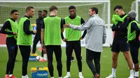 Pelatih Inggris Gareth Southgate berbicara dengan pemain selama sesi latihan di St George's Park di Burton-on-Trent, Inggris tengah (4/9). Inggris akan bertanding melawan Spanyol laga persahabatan internasional 8 September. (AFP Photo/Paul Ellis)