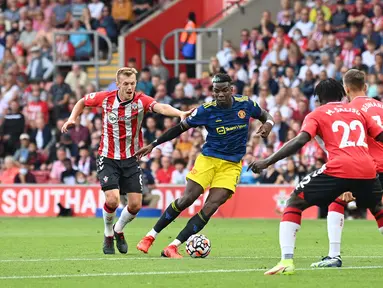 Pemain Manchester United Paul Pogba (kedua dari kiri) berlari ke arah gawang ketika pemain Southampton James Ward-Prowse (kiri) mengejar balik pada pertandingan Liga Inggris di Stadion St Mary, Southampton, Inggris, 22 Agustus 2021. Pertandingan berakhir imbang 1-1. (Glyn KIRK/AFP)