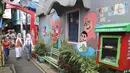 Pelajar melintas di Kampung Literasi RW 08, Jatipulo, Palmerah, Jakarta Barat, Kamis (30/1/2020). Kampung Literasi ini memiliki 5 kotak berisi beragam buku yang ada di sejumlah titik, berbekal konsep kejujuran disebar di sepanjang kampung. (Liputan6.com/Herman Zakharia)