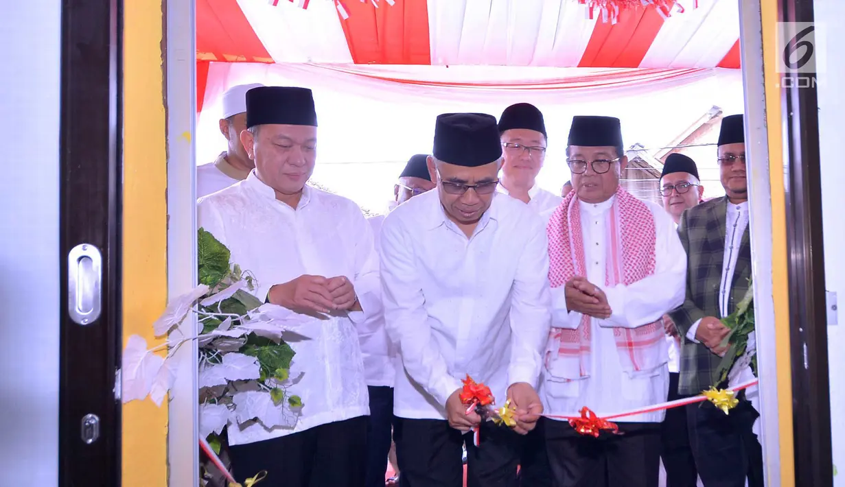 Ketua Dewan Komisioner OJK memotong pita disaksikan Gubernur Jambi Fachrori Umar dan Director in Charge Astra Financial Suparno Djasmin pada peresemian berdirinya Bank Wakaf Mikro ketiga di Pondok Pesantren As’ad, Olak Kemang, Jambi Rabu (3/4). (Liputan6.com/HO/Eko)
