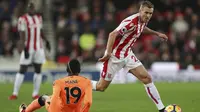 Gelandang Stoke, Darren Fletcher, melewati striker Liverpool, Sadio Mane, yang terjatuh pada laga Premier League di Stadion Bet365, Stoke-on-Trent, Rabu (29/11/2017). Stoke kalah 0-3 dari Liverpool. (AP/David Davies)