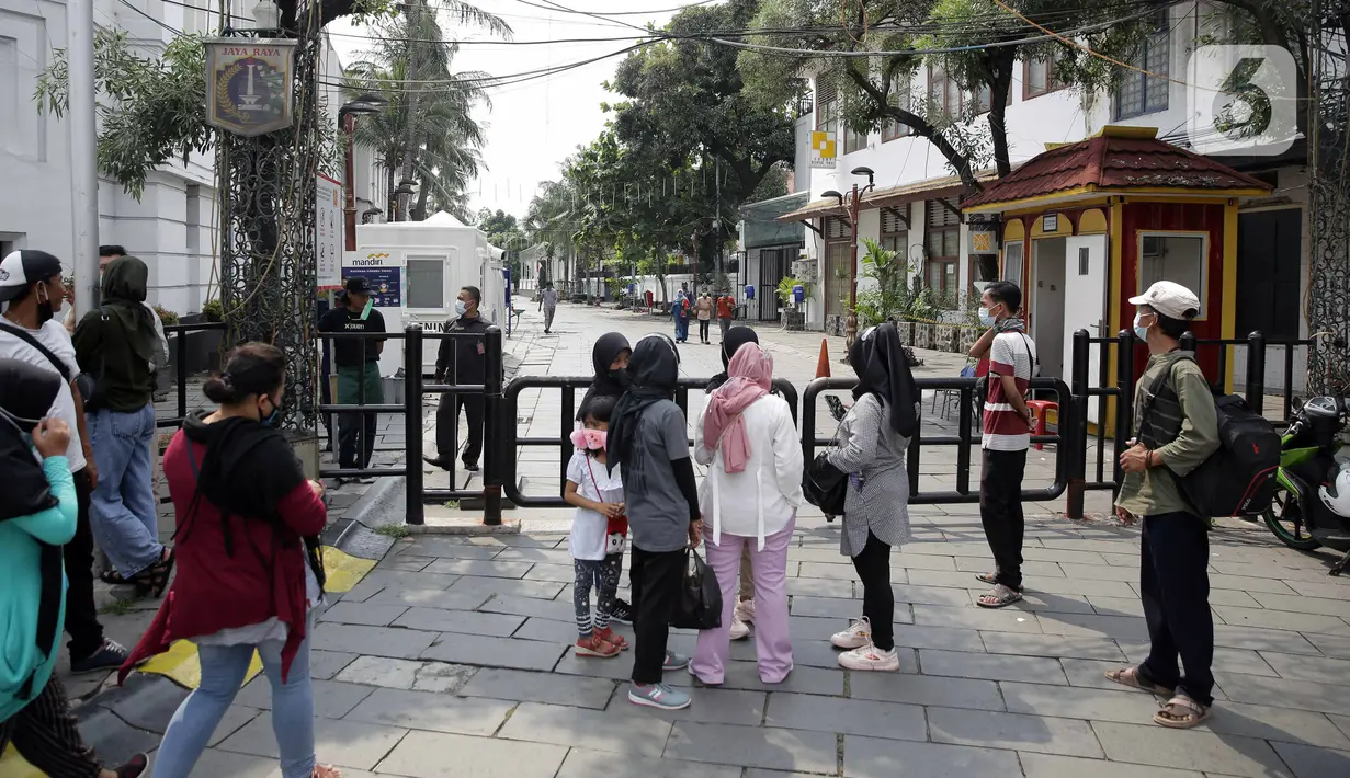 Pengunjung berkumpul di depan pintu masuk kawasan wisata Kota Tua, Jakarta, Sabtu (15/5/2021). Pemerintah Provinsi DKI Jakarta menutup kawasan wisata Kota Tua untuk mengurangi kerumunan selama libur Lebaran 2021. (Liputan6.com/Faizal Fanani)
