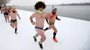 Para peserta bertelanjang dada saat mengikuti Underpants Run di tepi sungai Danube, Serbia pada 26 Januari 2019. Peserta berlari hanya dengan mengenakan pakaian dalam di tengah suhu yang mendekati 0 derajat Celcius. (AP/Darko Vojinovic)