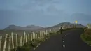 Seorang wanita berjalan menyusuri jalan di Coumeenoole, Irlandia, Selasa (27/12). Irlandia mendapat julukan Pulau Zamrud karena memiliki pemandangan alam yang hijau terang. (REUTERS / Clodagh Kilcoyne)