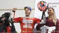 Pembalap Ducati, Andrea Dovizioso berselebrasi usai berhasil memenangkan seri pembuka MotoGP di Sirkuit Internasional Losail di Doha, Qatar (10/3). Dovizioso berhasil mengalahkan Marc Marquez dengan selisih waktu 0,023 detik. (AP Photo/Hanson Joseph)