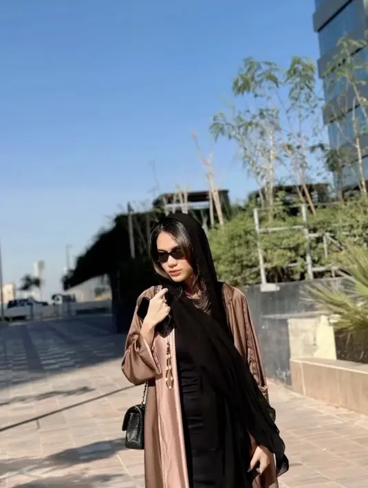 Outer panjang tersebut dipadukan dress bodycon hitam. Sambil membawa sling bag hitam.[@azizahsalsha_]