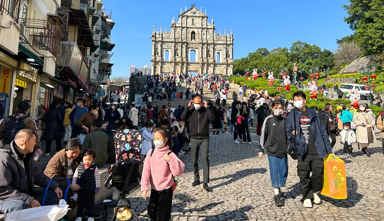 Pelancong dari China daratan berkumpul dekat Reruntuhan St. Paul's, tujuan wisata di Makau, 18 Januari 2022. Ledakan pariwisata China yang diharapkan selama liburan Tahun Baru Imlek minggu depan tampaknya akan lebih cepat terjadi. (AP Photo/Kanis Leung)