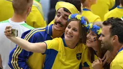 Fans Swedia melakukan selfie sebelum menyaksikan laga timnya melawan Irlandia pada Grud E Euro 2016 di Stadion Stade de France, Saint-Denis, (13/6/2016). (AFP/Paul Ellis)