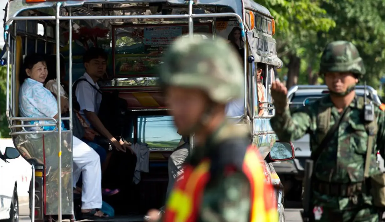 Beberapa tentara Thailand terlihat terus berjaga di sebuah pos pemeriksaan dekat perkemahan massa pendukung pemerintah, (22/5/2014). (AFP PHOTO/Manan Vatsyayana)