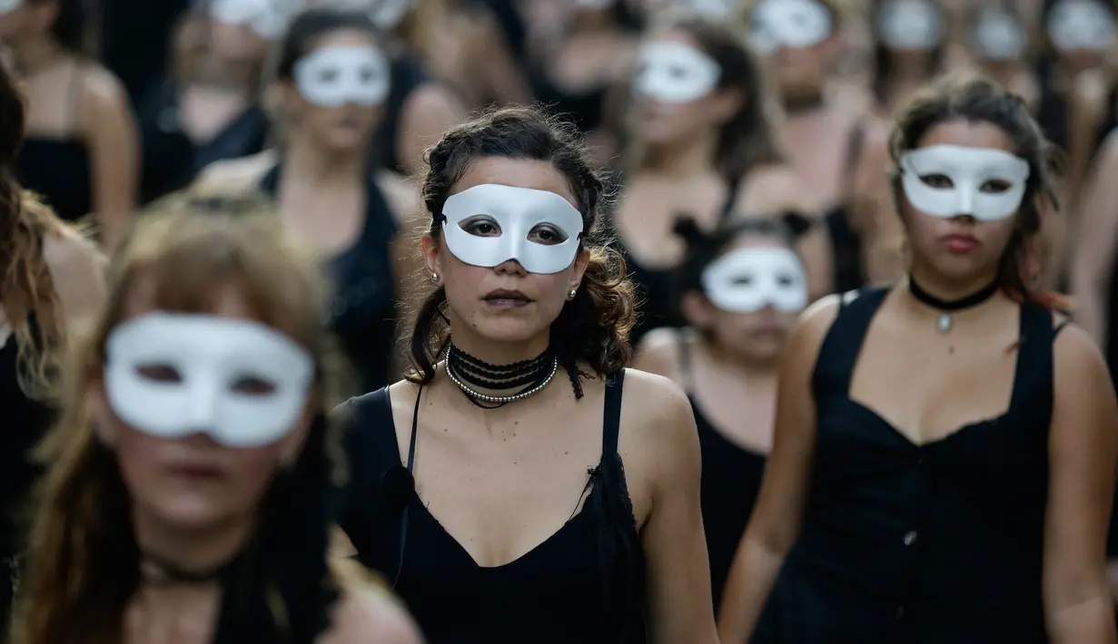 Sejumlah wanita mengenakan pakaian hitam dan topeng mengikuti peringatan 41 tahun kudeta militer di Buenos Aires, Argentina (24/3). Mereka memperingati jatuhnya junta militer yang dipimpin oleh diktator militer Jorge Videla. (AP Photo/Victor R. Caivano)
