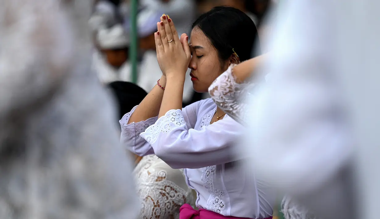 Umat Hindu berkumpul untuk berdoa di sebuah pura merayakan Galungan di Denpasar, Bali, Rabu (2/8/2023). (Photo by SONNY TUMBELAKA / AFP)