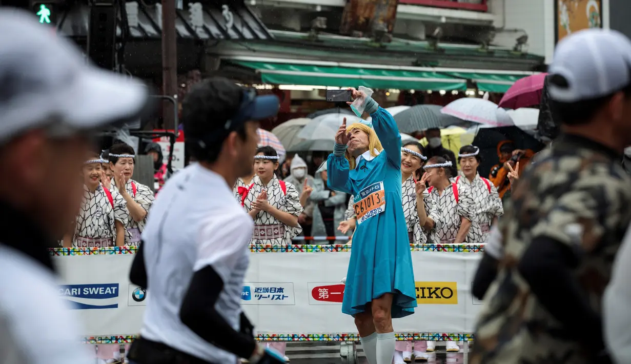 Seorang peserta berselfie saat mengikuti ajang Tokyo Marathon 2019 di Jepang, Minggu (3/3). Sebagian peserta tampil dengan mengenakan kostum unik seperti tokoh kartun. (AFP Photo/Behrouz Mehri)