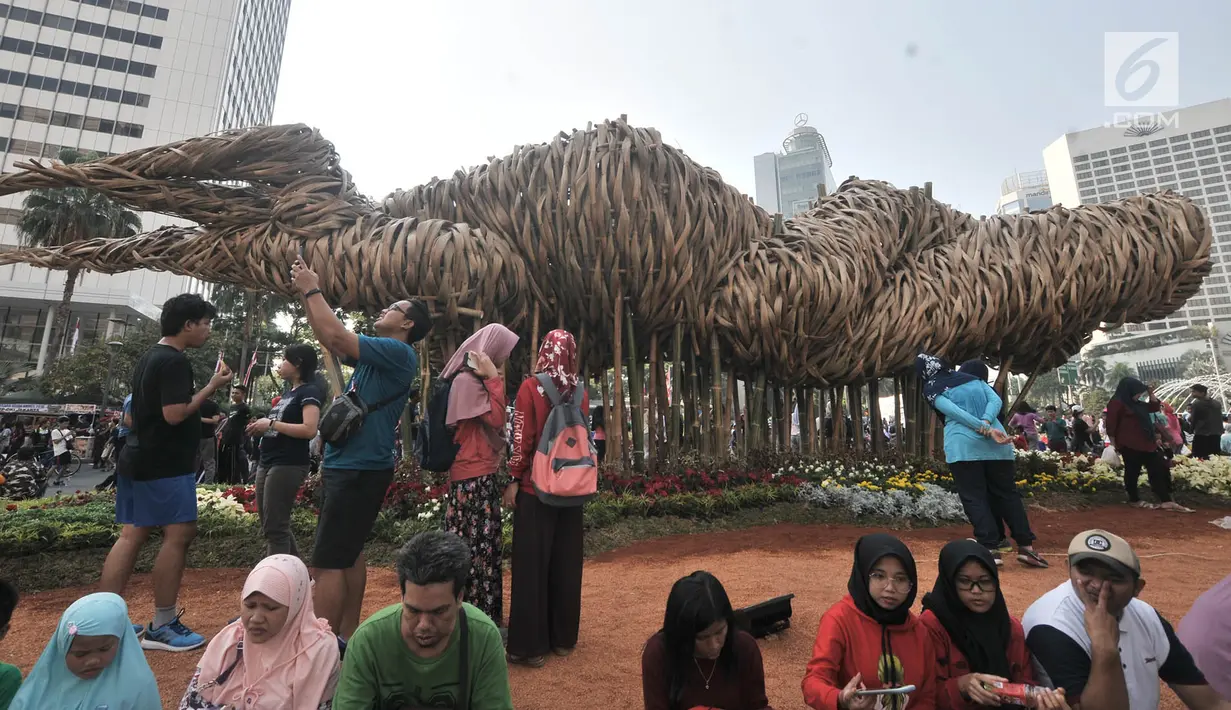Instalasi bambu "Getih Getah" di Bundaran HI menjadi daya tarik pengunjung car free day, Jakarta, Minggu (19/8). Instalasi seni karya Joko Avianto itu dikelilingi warga yang hendak berfoto atau sekedar melihat-lihat. (Merdeka.com/ Iqbal S. Nugroho)