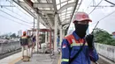 Petugas keamanan berkomunikasi menggunakan radio saat mengawasi laju kereta yang akan melintas di Stasiun Matraman, Jakarta Timur, Kamis (23/12/2021). BTPWJB terus mengebut pembangunan Stasiun Matraman yang ditargetkan dapat beroperasi pada 2022 mendatang. (merdeka.com/Iqbal S. Nugroho)