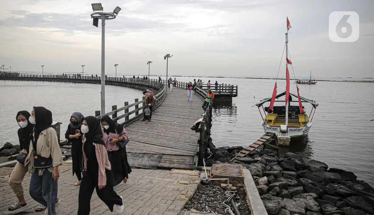Pengujung berwisata di Pantai Ancol, Jakarta, Rabu (28/12/2022). Isu cuaca yang kurang bersahabat pada hari ini, tidak menyurutkan keinginan warga menghabiskan libur untuk berwisata di kawasan wisata Ancol. (Liputan6.com/Faizal Fanani)