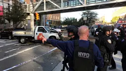 Polisi NYPD mendatangi lokasi sebuah truk yang menabrak pejalan kaki dan pesepeda di Lower Manhattan, New York, Selasa (31/10). Lokasi serangan ini berdekatan dengan World Trade Center (WTC) yang jaraknya berkisar 983 meter. (Martin Speechley/NYPD via AP)